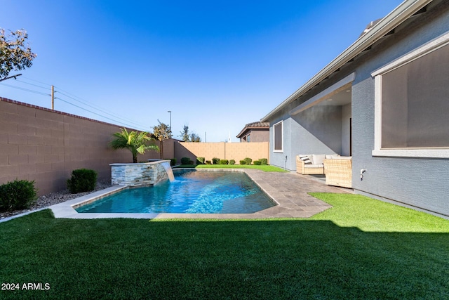 view of swimming pool with a yard, pool water feature, and a patio