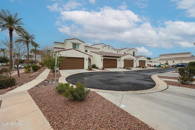 view of front of home featuring a tile roof, stucco siding, and aphalt driveway