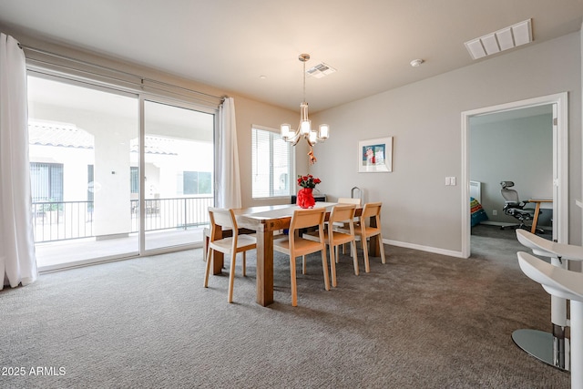 dining area with a chandelier and dark colored carpet