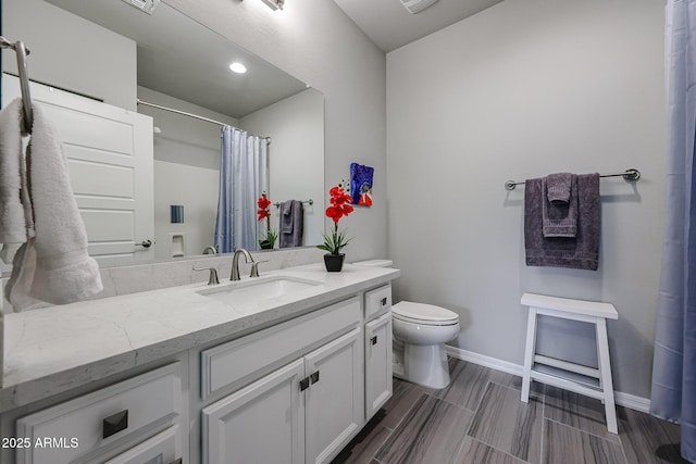 bathroom featuring vanity, curtained shower, and toilet