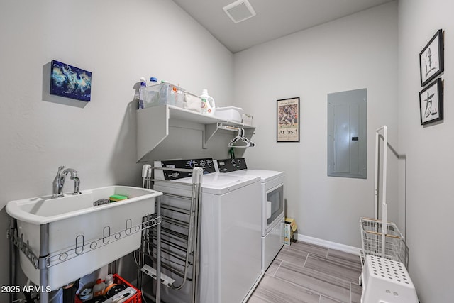 clothes washing area featuring separate washer and dryer, sink, and electric panel