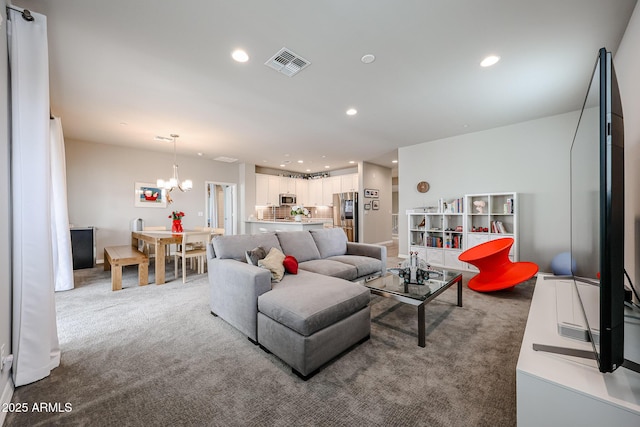 carpeted living room featuring a notable chandelier