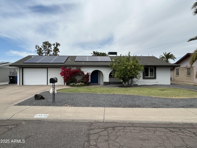 3516 W Brown St, Phoenix, AZ 85051 - ranch-style home featuring a garage, driveway, a front lawn, roof mounted solar panels, and stucco siding