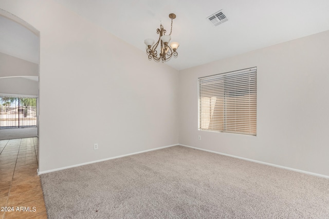 unfurnished room with lofted ceiling, light tile patterned floors, and a chandelier