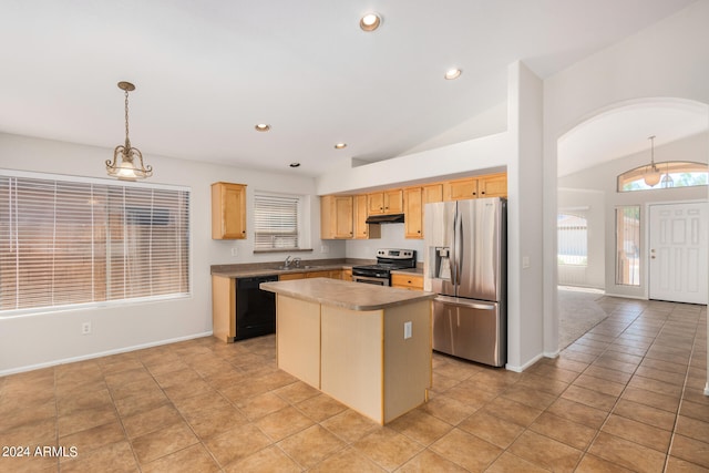 kitchen featuring hanging light fixtures, light brown cabinetry, a center island, vaulted ceiling, and appliances with stainless steel finishes