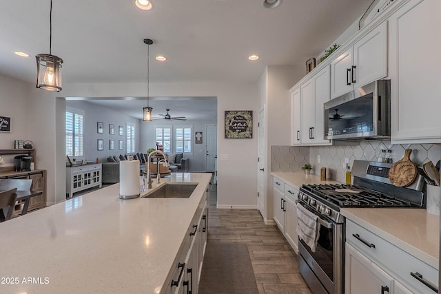 kitchen with a ceiling fan, white cabinets, recessed lighting, a sink, and stainless steel appliances