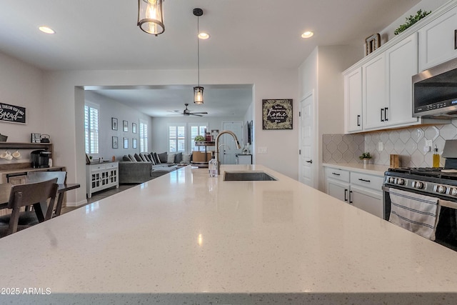 kitchen featuring a ceiling fan, recessed lighting, a sink, stainless steel appliances, and open floor plan
