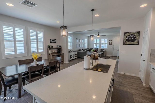 kitchen featuring a ceiling fan, visible vents, recessed lighting, a sink, and dark wood-style floors