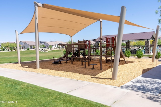 communal playground featuring a yard and fence
