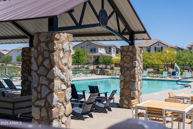pool with a patio and fence