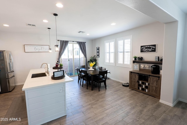 dining space featuring wood finished floors, baseboards, visible vents, and recessed lighting