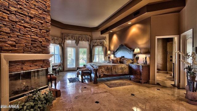 bedroom with a high ceiling and a fireplace