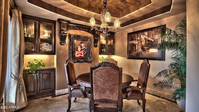 dining space featuring an inviting chandelier and a raised ceiling