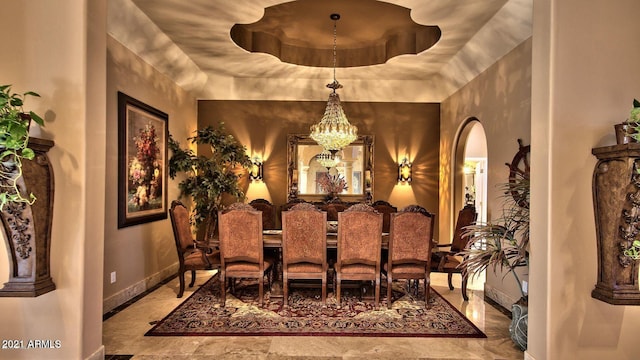 dining space with a raised ceiling