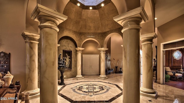 interior space with decorative columns and a towering ceiling