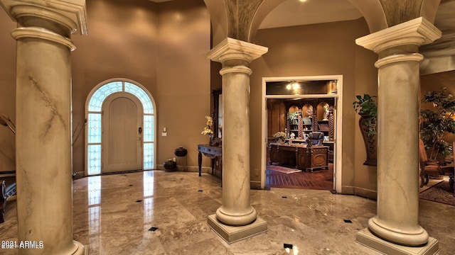 foyer with a high ceiling and ornate columns