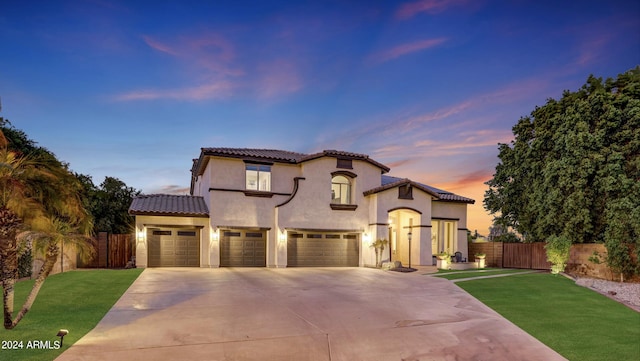 mediterranean / spanish house featuring a yard and a garage