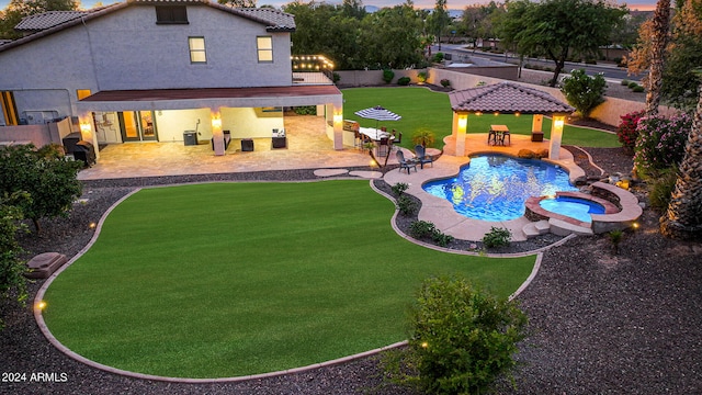 view of pool with a gazebo, an in ground hot tub, a patio area, and a lawn