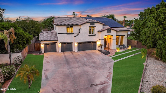 mediterranean / spanish-style home with a lawn and a garage