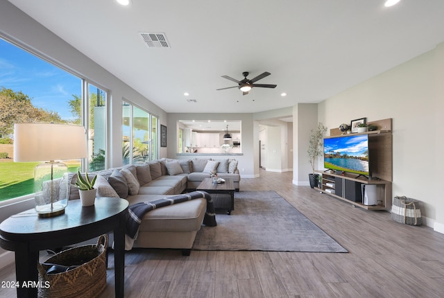 living room featuring wood-type flooring and ceiling fan