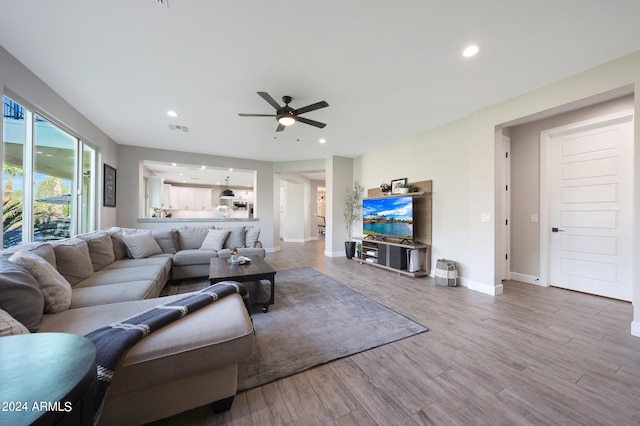 living room featuring ceiling fan and light hardwood / wood-style flooring