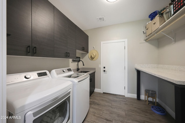 washroom featuring cabinets, independent washer and dryer, dark wood-type flooring, and sink