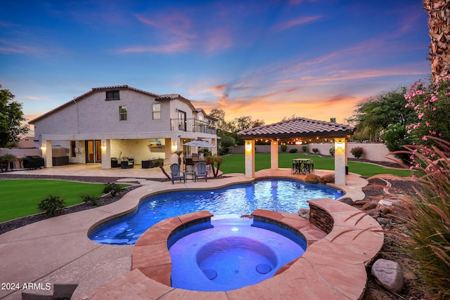 pool at dusk featuring a patio, a gazebo, a lawn, and an in ground hot tub