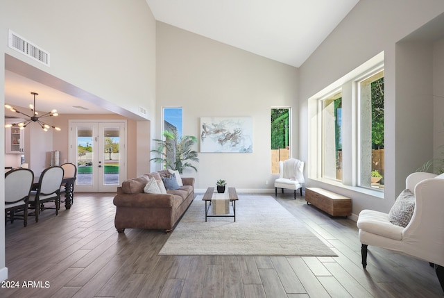 living room featuring wood-type flooring, a notable chandelier, plenty of natural light, and french doors