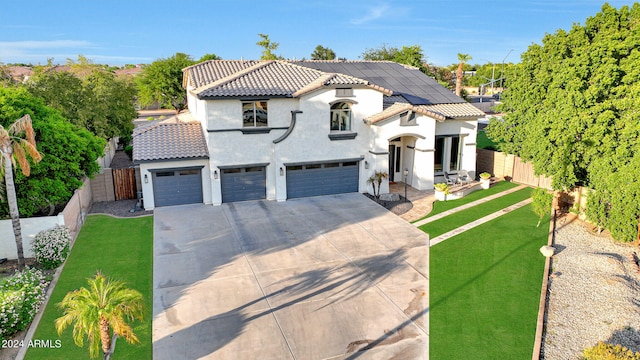 mediterranean / spanish-style home with a garage and a front lawn