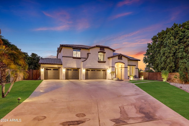 mediterranean / spanish house featuring a lawn and a garage