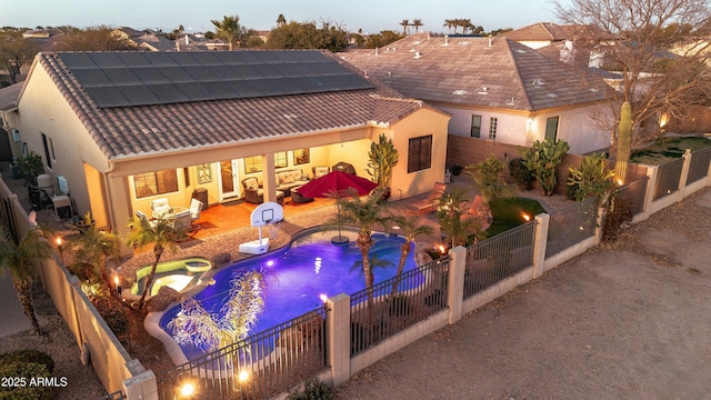 pool at dusk with a jacuzzi, a fire pit, and a patio