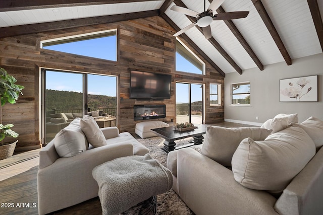 9661 W Coyote Dr, Strawberry, AZ 85544 - living area with wood walls, a glass covered fireplace, beamed ceiling, and dark wood finished floors