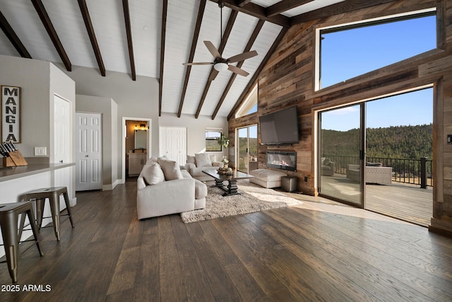 9661 W Coyote Dr, Strawberry, AZ 85544 - living room with dark wood-type flooring, a fireplace, beamed ceiling, and a wealth of natural light