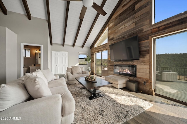 9661 W Coyote Dr, Strawberry, AZ 85544 - living room with beam ceiling, wood finished floors, a glass covered fireplace, visible vents, and ceiling fan