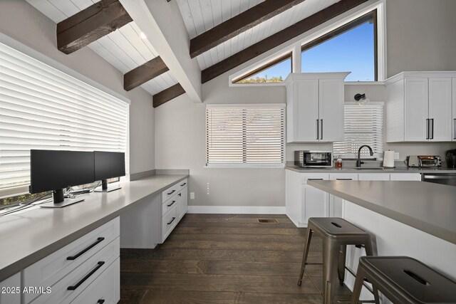 9661 W Coyote Dr, Strawberry, AZ 85544 - kitchen with a sink, lofted ceiling with beams, a kitchen breakfast bar, white cabinets, and dark wood-style flooring