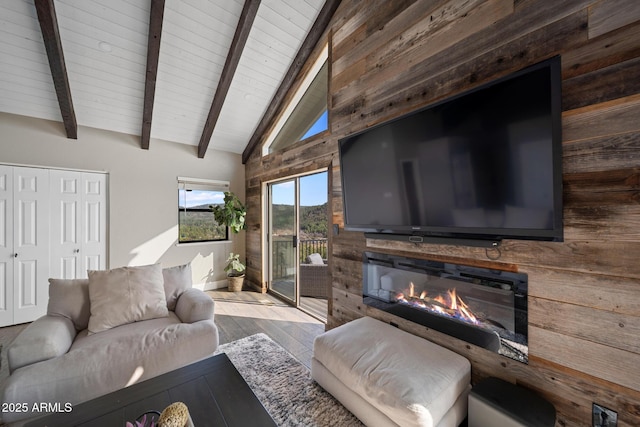9661 W Coyote Dr, Strawberry, AZ 85544 - living area featuring wood ceiling, vaulted ceiling with beams, wood finished floors, wood walls, and a glass covered fireplace