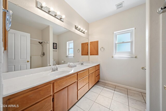 bathroom with tile patterned flooring, toilet, walk in shower, and vanity