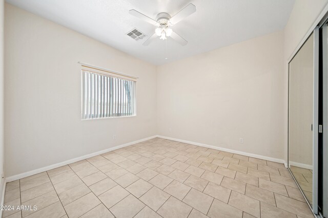 interior space featuring light tile patterned floors, ceiling fan, and a closet