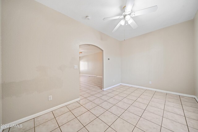 tiled spare room featuring ceiling fan