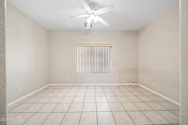 tiled spare room with ceiling fan