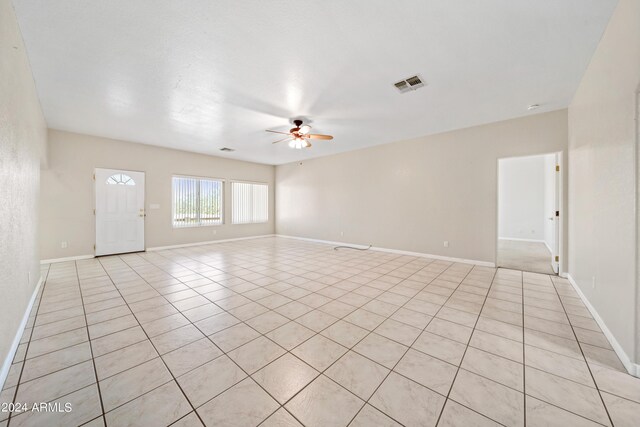 empty room featuring light tile patterned floors and ceiling fan