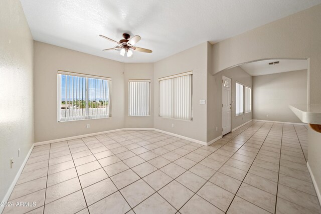 tiled spare room with ceiling fan and a textured ceiling