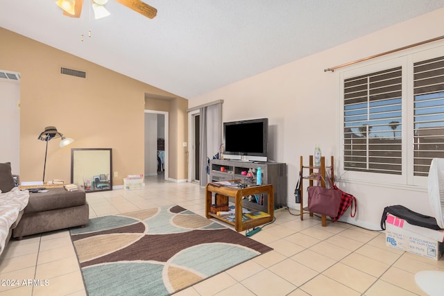 tiled living room with ceiling fan and vaulted ceiling