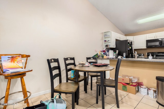 dining space featuring vaulted ceiling and light tile patterned floors