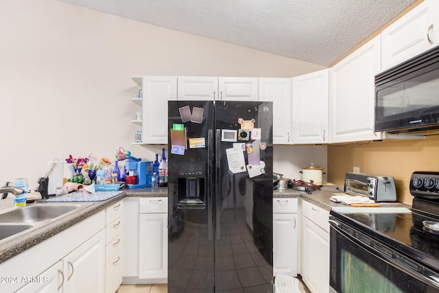 kitchen with a textured ceiling, white cabinetry, black appliances, and vaulted ceiling