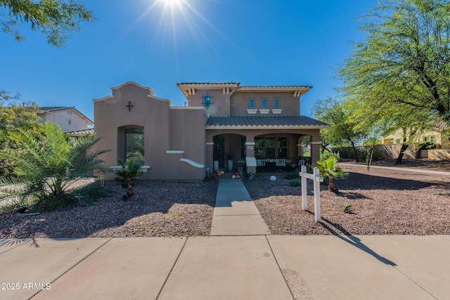 20557 W Lost Creek Dr, Buckeye, AZ 85396 - mediterranean / spanish-style house with a porch, stucco siding, and a tiled roof