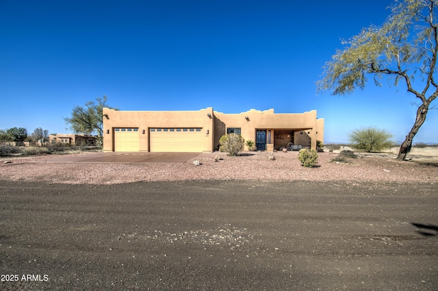 pueblo revival-style home with a garage