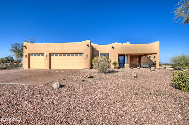 pueblo revival-style home featuring a garage