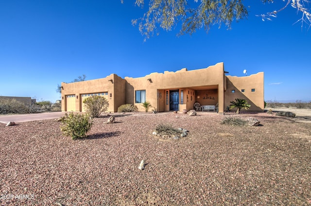 pueblo revival-style home featuring a garage