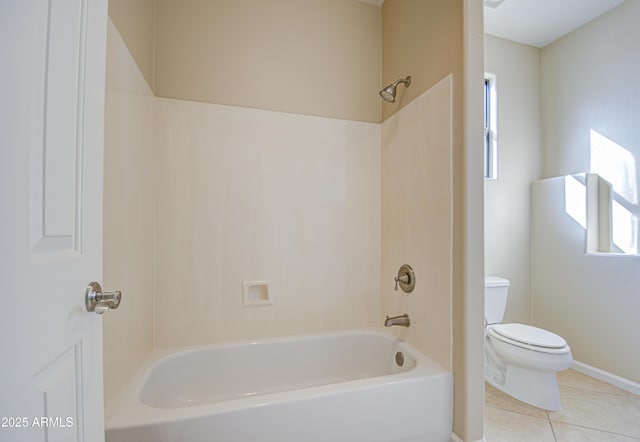 bathroom with plenty of natural light, tile patterned floors, washtub / shower combination, and toilet